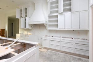 Kitchen cabinets mid-project showing how long cabinet painting takes with doors removed and cabinet boxes exposed during the professional painting process.