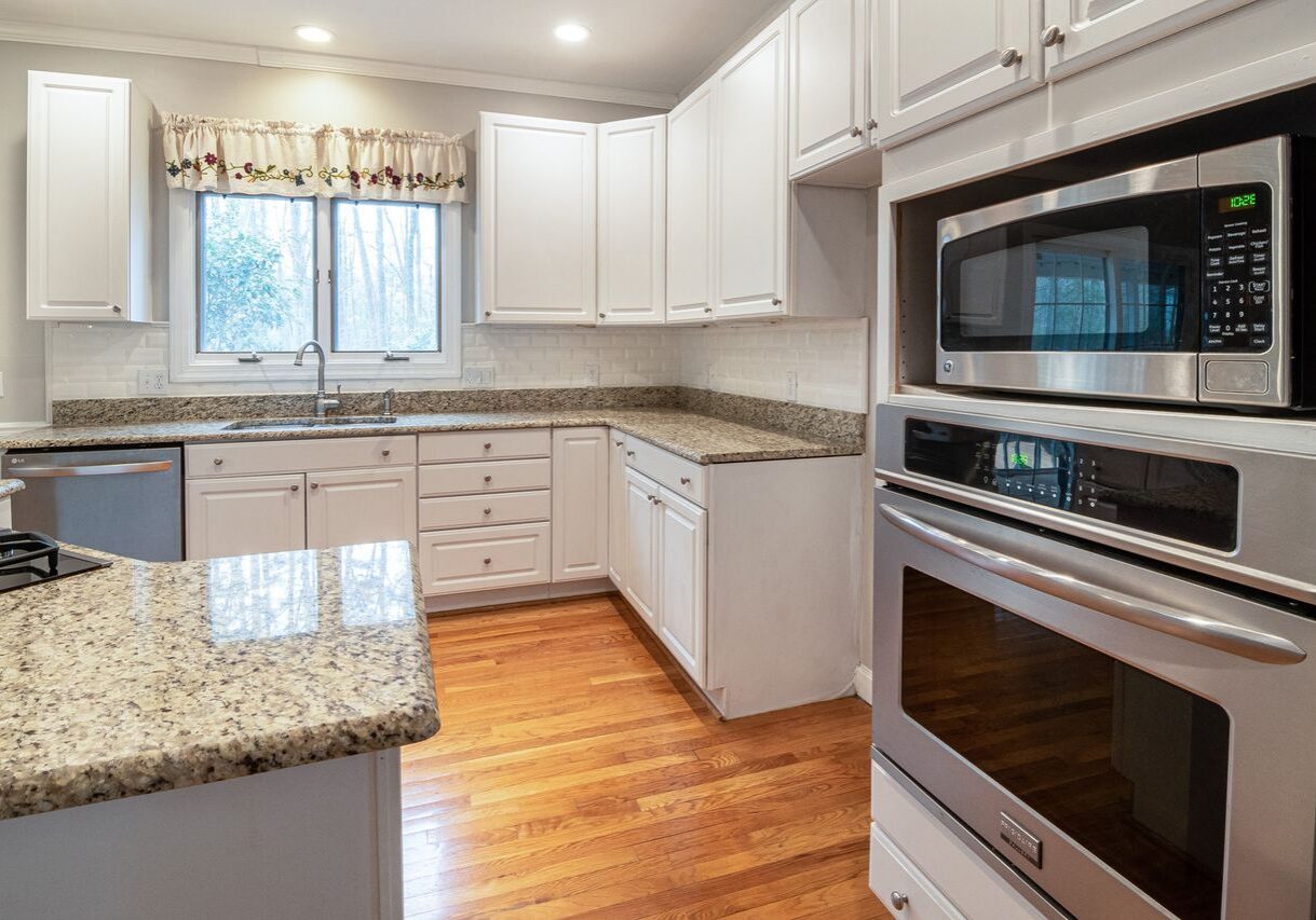White painted kitchen cabinets with granite countertops and hardwood floors in a Santa Rosa, CA home
